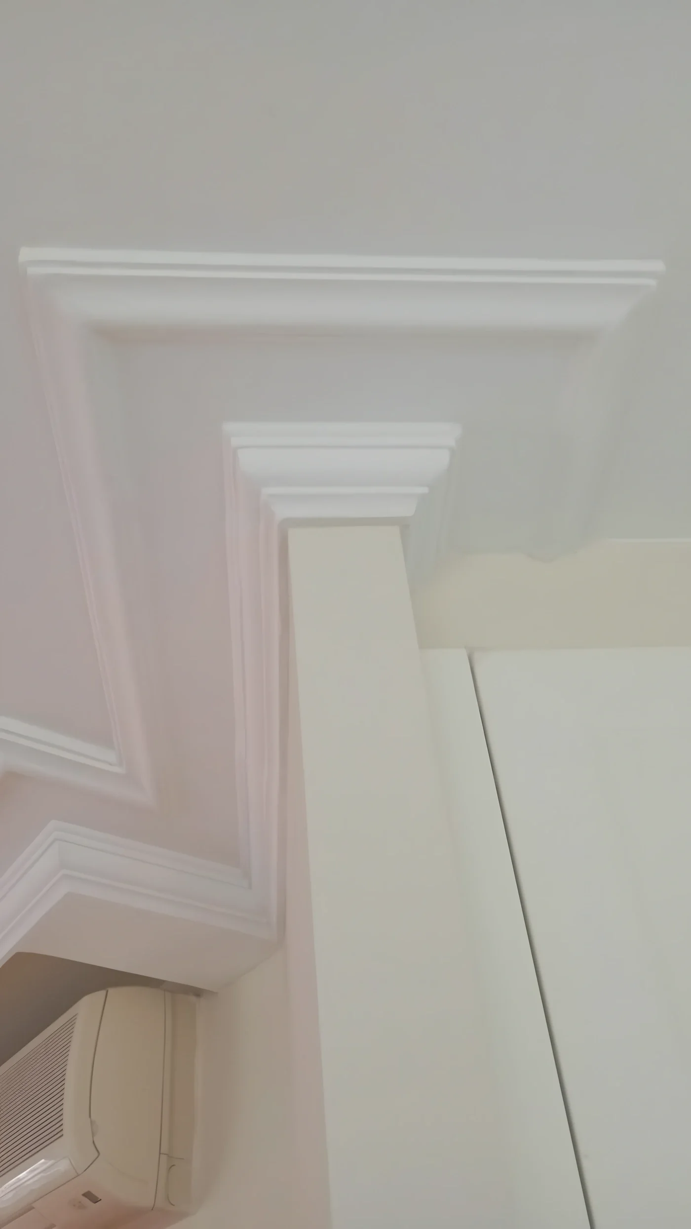 Detalle de una moldura y un capitel de escayola pintados en blanco